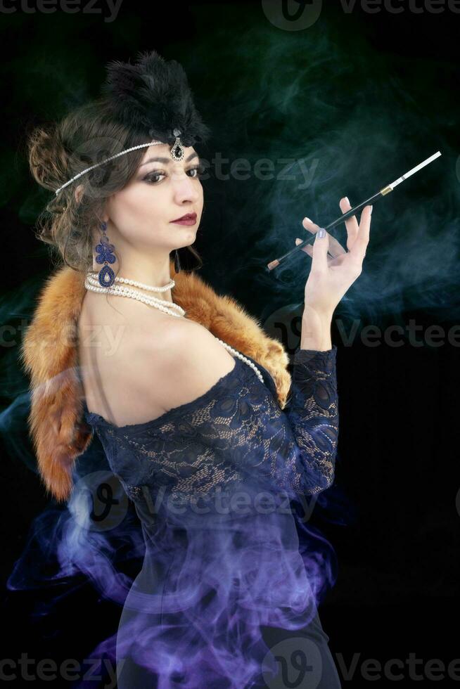 retro vrouw portret. mooi vrouw in de stijl van Jaren 20 of Jaren 30 met een mondstuk in gekleurde rook. foto