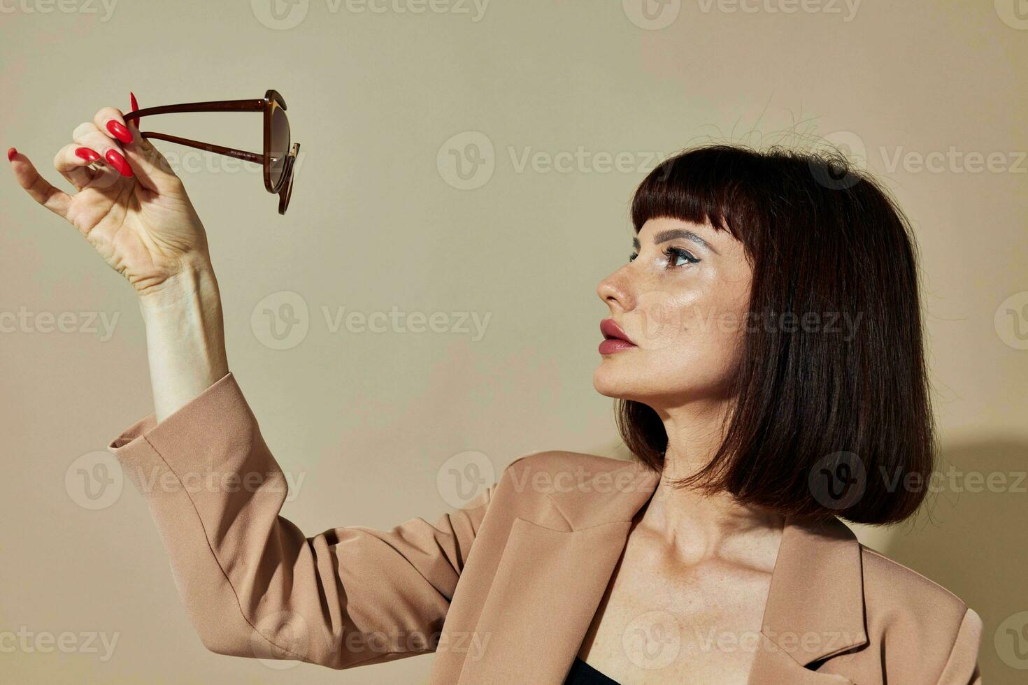 portret van een vrouw in een beige jasje elegant stijl zonnebril levensstijl ongewijzigd foto