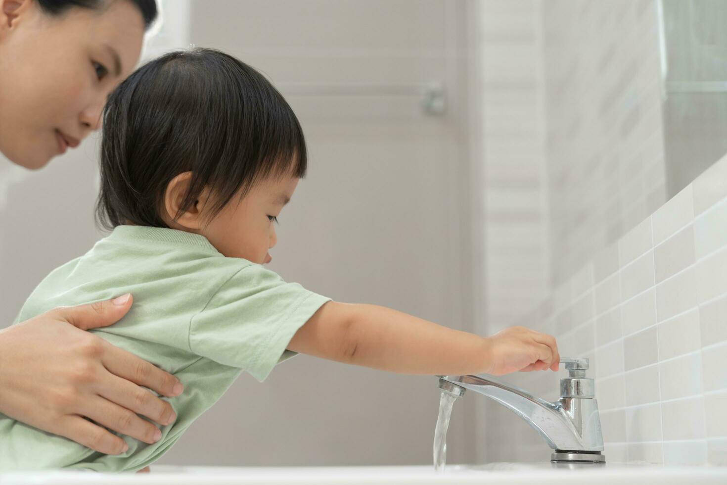 weinig kind handen wassen met zeep bubbels en spoelen met schoon water naar voorkomen en hou op de verspreiding van kiemen na terug naar huis, virus of covid19. mooi zo Gezondheid en mooi zo persoonlijk hygiëne, virus, bacterie foto