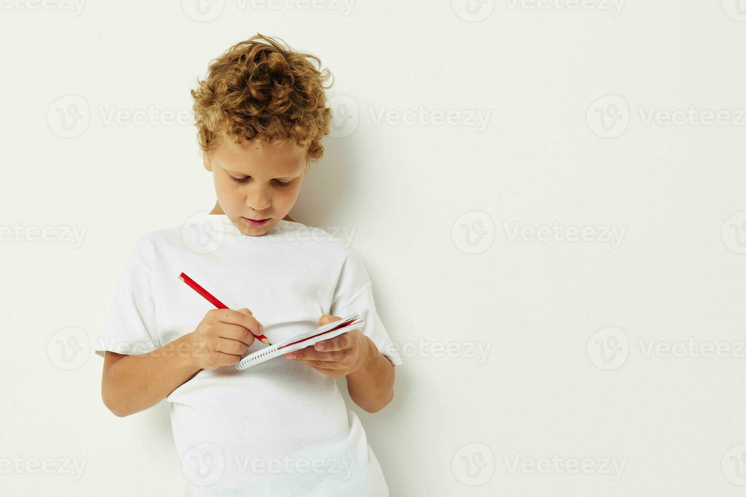 jongen trekt met potlood in notitieboekje vermaak studio foto