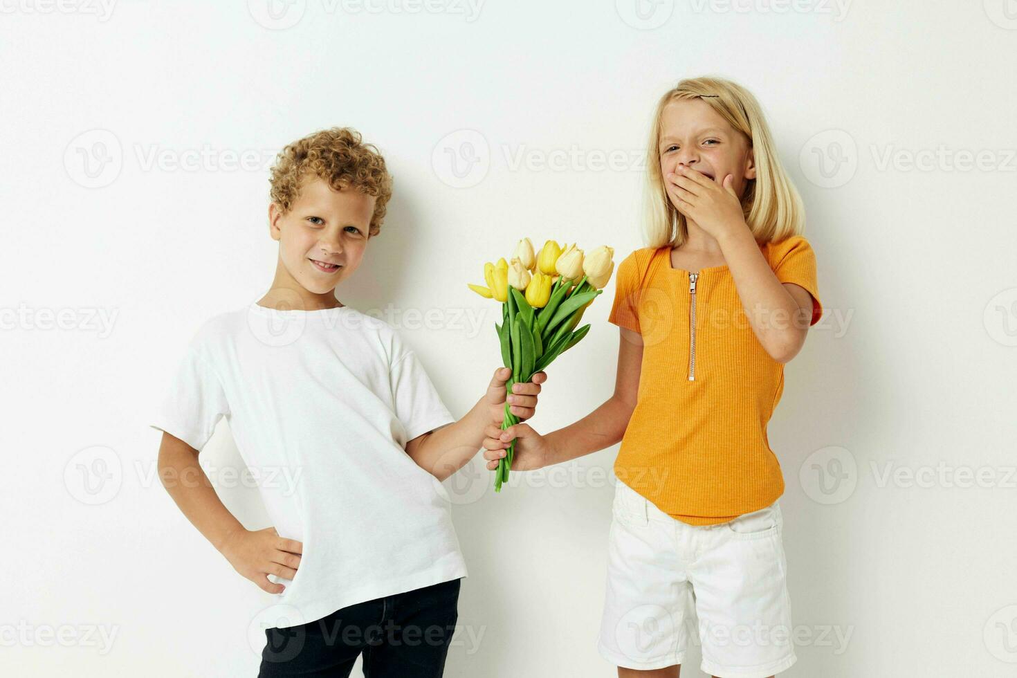 jongen en meisje met een boeket van bloemen geschenk verjaardag vakantie kinderjaren licht achtergrond foto