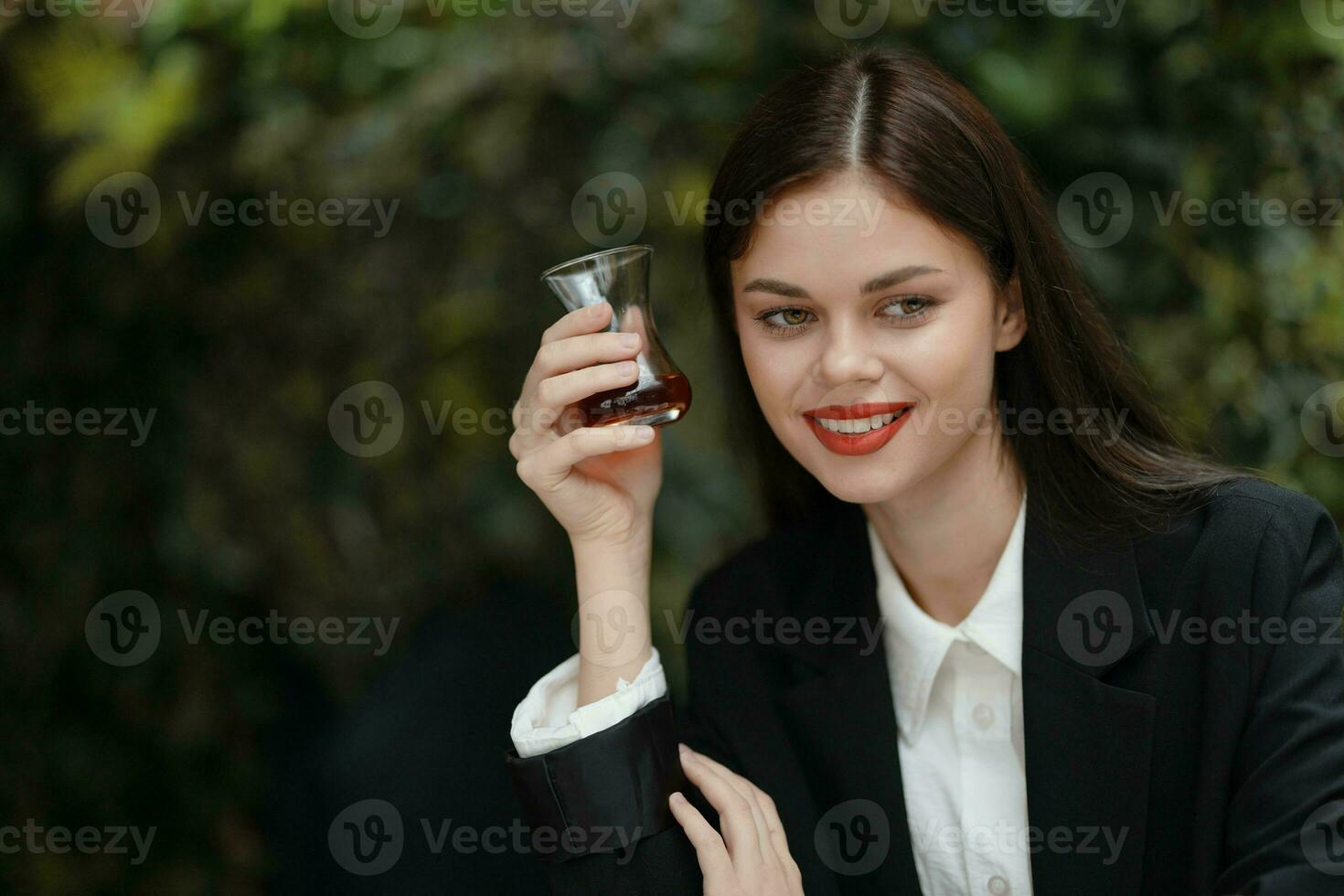vrouw glimlach met tanden drinken thee in een cafe van een Turks glas mok Aan de straat, voorjaar reis, stad breken foto
