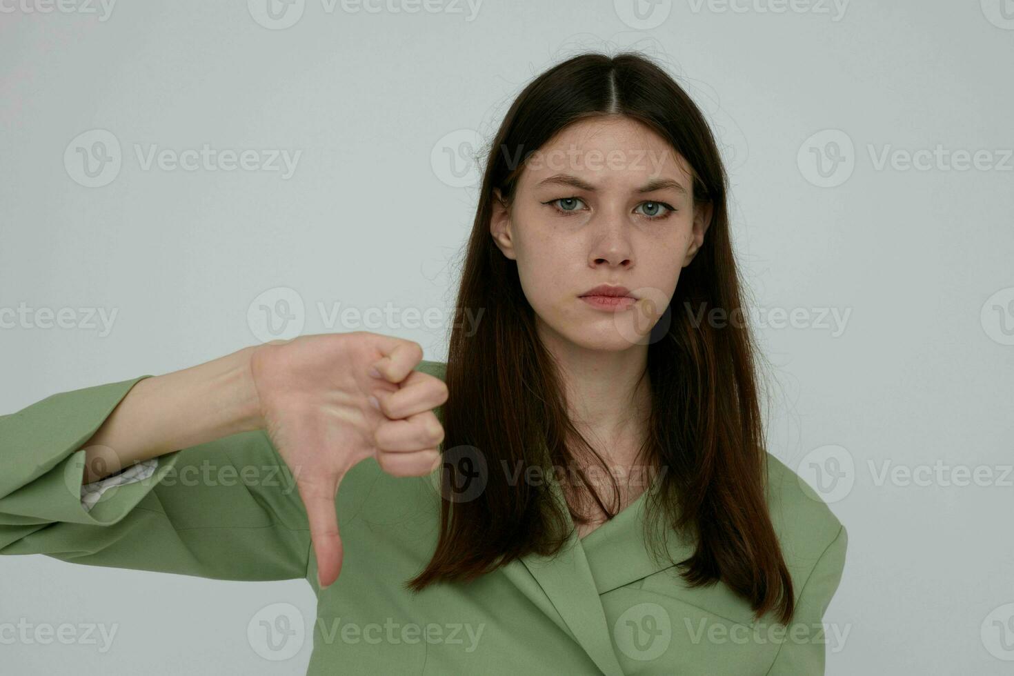 mooi brunette in groen jasje poseren mode licht achtergrond foto