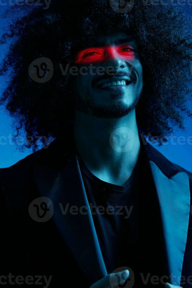 mode portret van een Mens met gekruld haar- Aan een blauw achtergrond met een rood streep van licht, veelkleurig licht, trendy, modern concept. foto