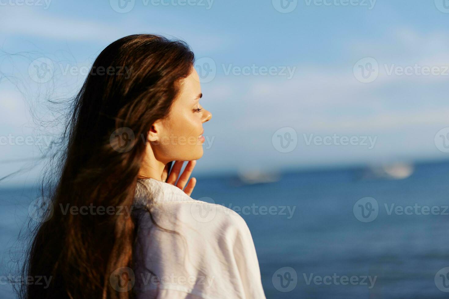 vrouw schoonheid glimlach met tanden vrijheid Aan vakantie wandelen Aan de strand door de oceaan in Bali zonsondergang, gelukkig reizen en vakantie, zonsondergang licht, vliegend haar, huid en haar- zorg concept in de zon foto