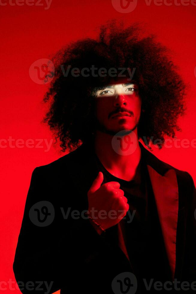 mode portret van een Mens met gekruld haar- Aan een rood achtergrond, multinationaal, gekleurde licht, trendy, modern concept. foto