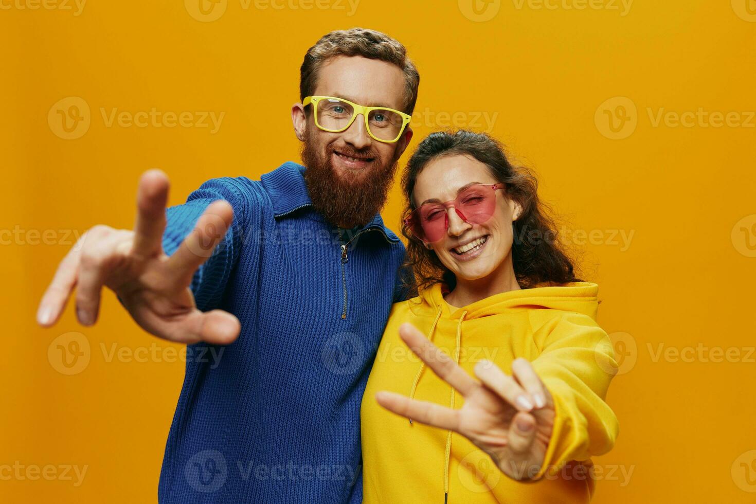 Mens en vrouw paar glimlachen vrolijk en scheef met bril, Aan geel achtergrond, symbolen tekens en hand- gebaren, familie schieten, pasgetrouwden. foto