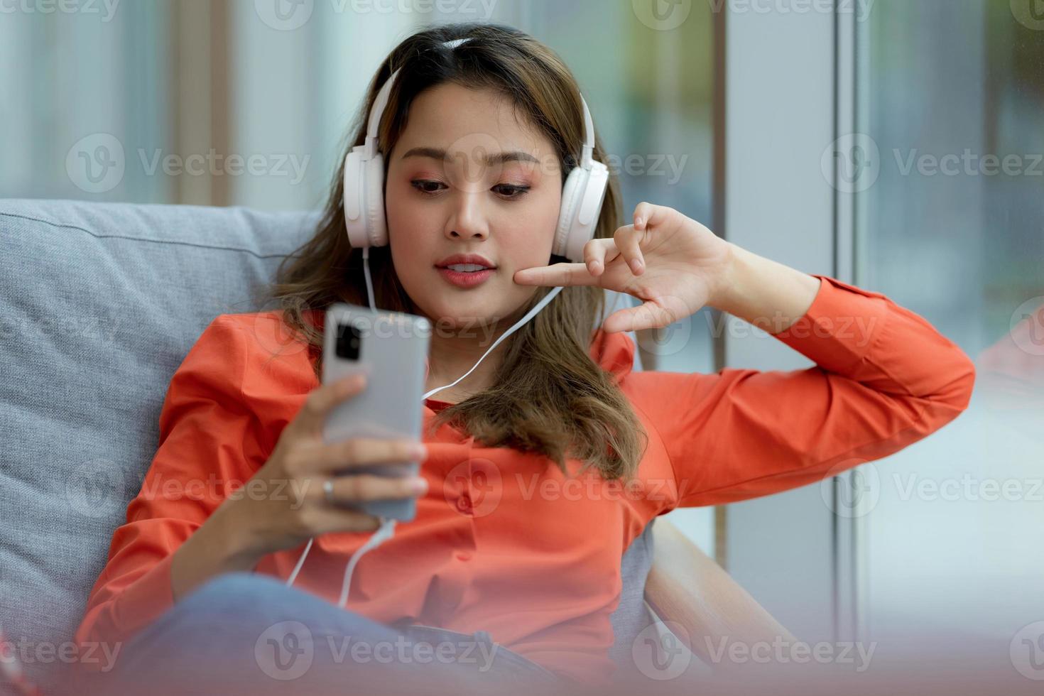 portret van jonge mooie vrouw genieten van de muziek met smileygezicht zitten in creatieve kantoor of café foto