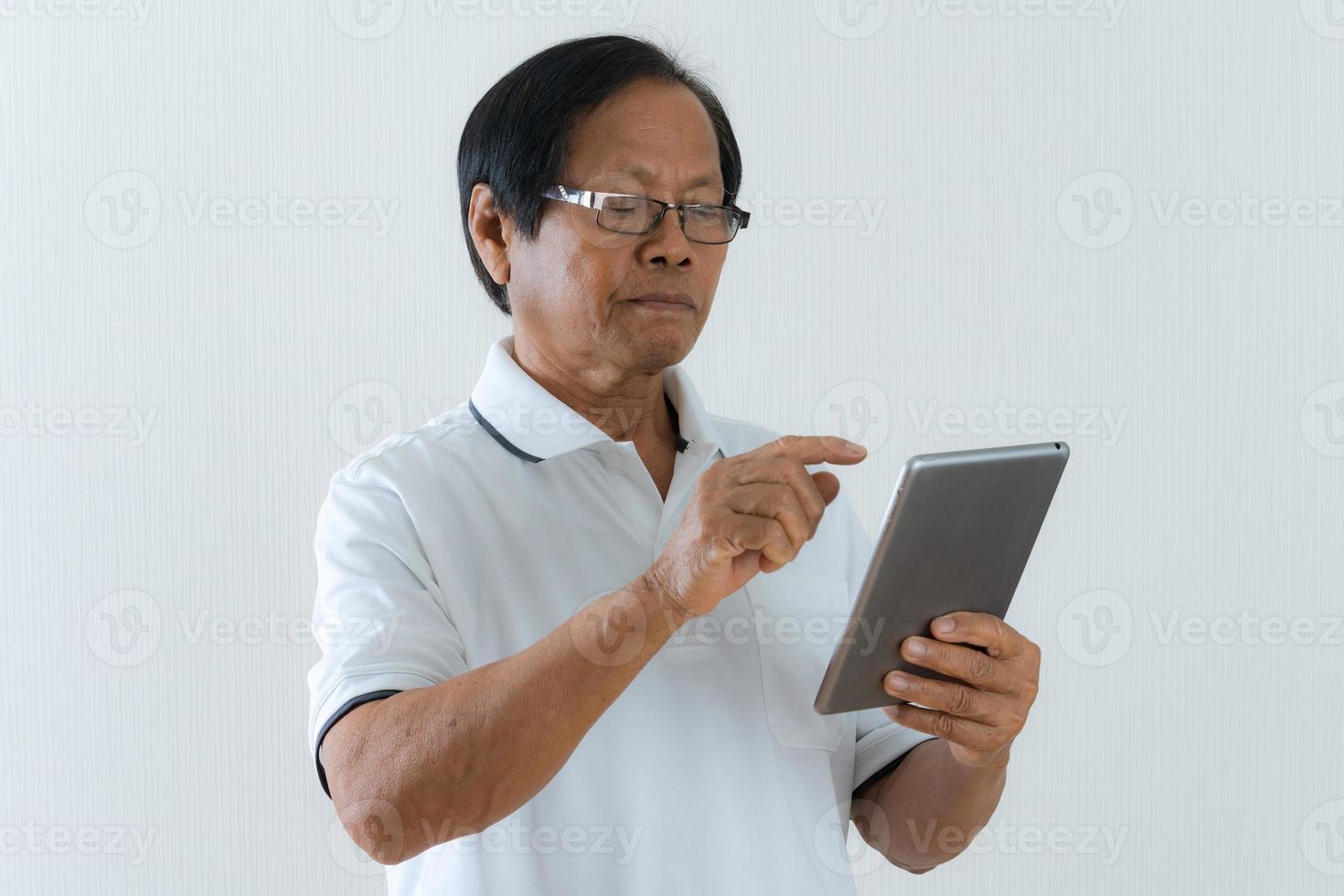 portret van Aziatische senior man met behulp van een digitale tablet foto