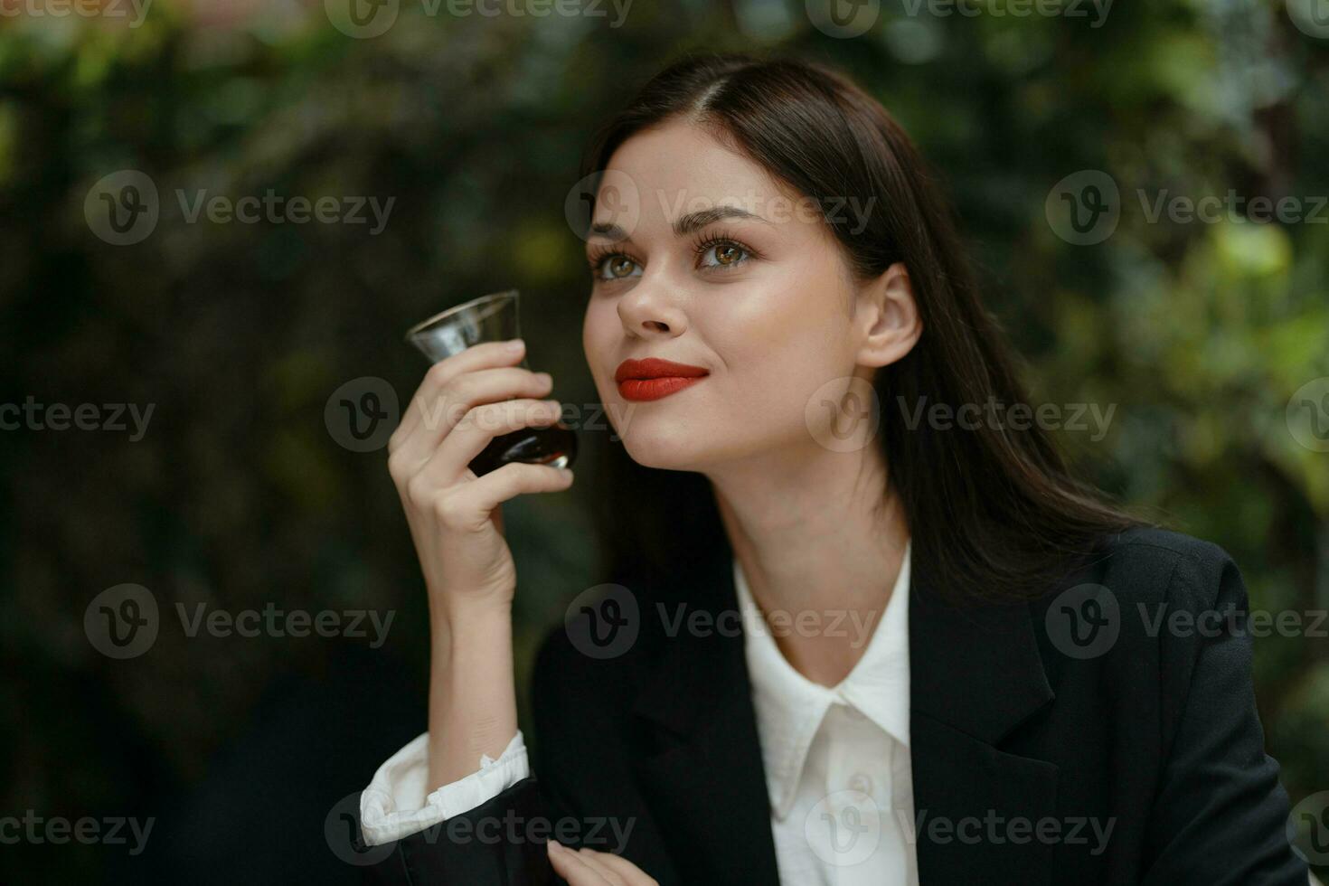 vrouw glimlach met tanden drinken thee in een cafe van een Turks glas mok Aan de straat, voorjaar reis, stad breken foto