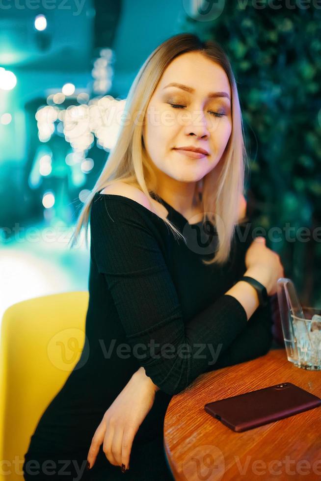 mooi meisje in zwarte jurk in restaurant foto