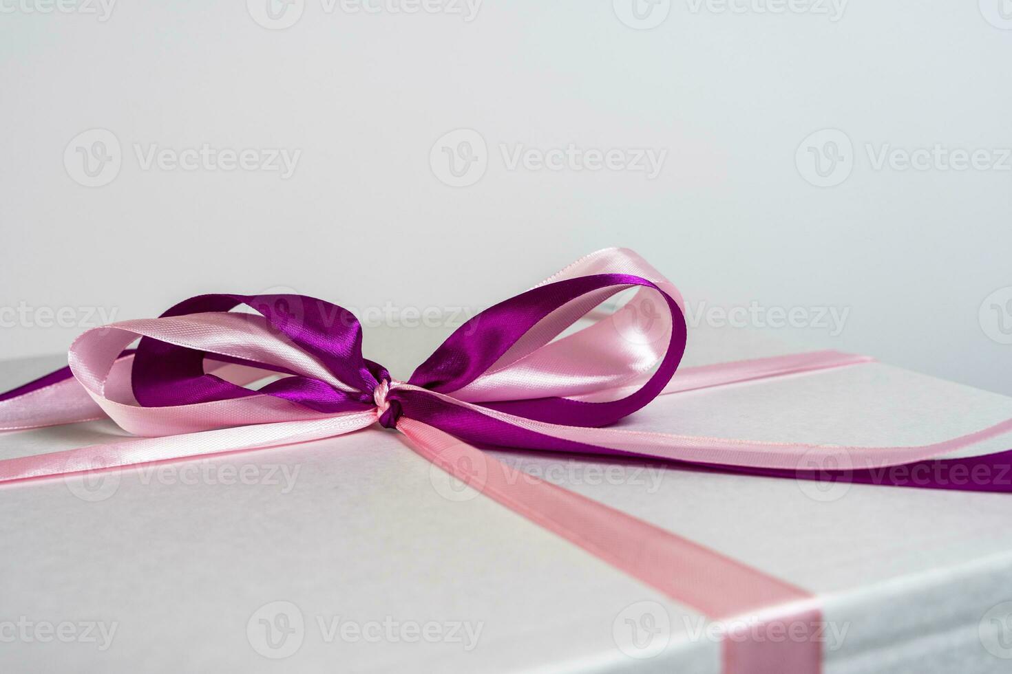 detailopname van een rood satijn lint boog Aan een wit geschenk doos foto