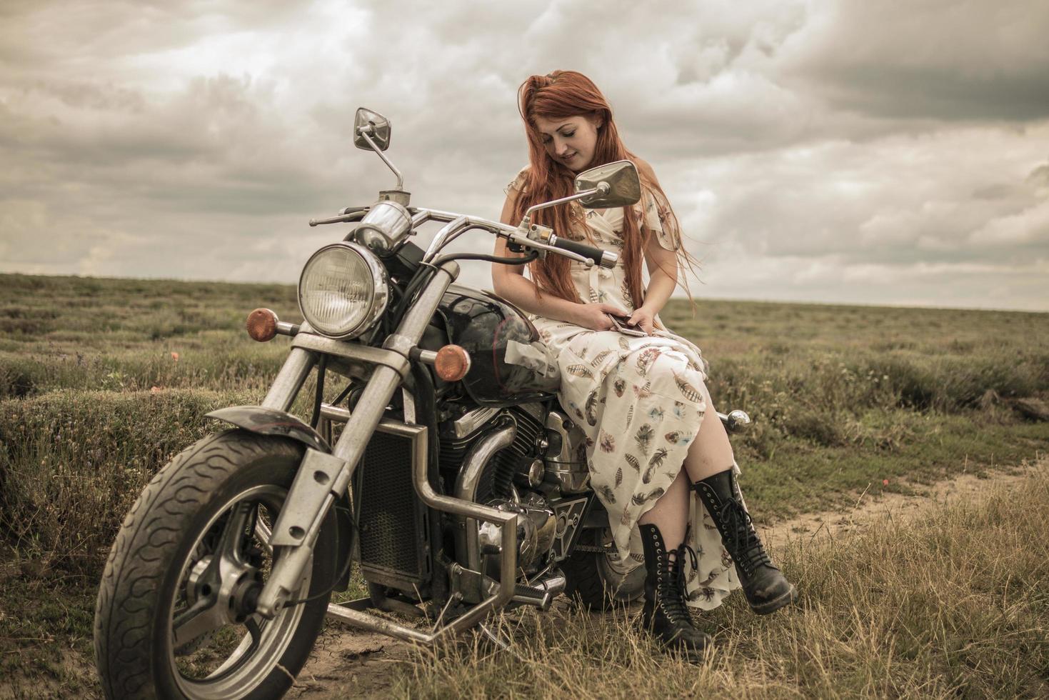 roodharig meisje in een witte jurk en laarzen, samen met een motorfiets lavendelveld foto