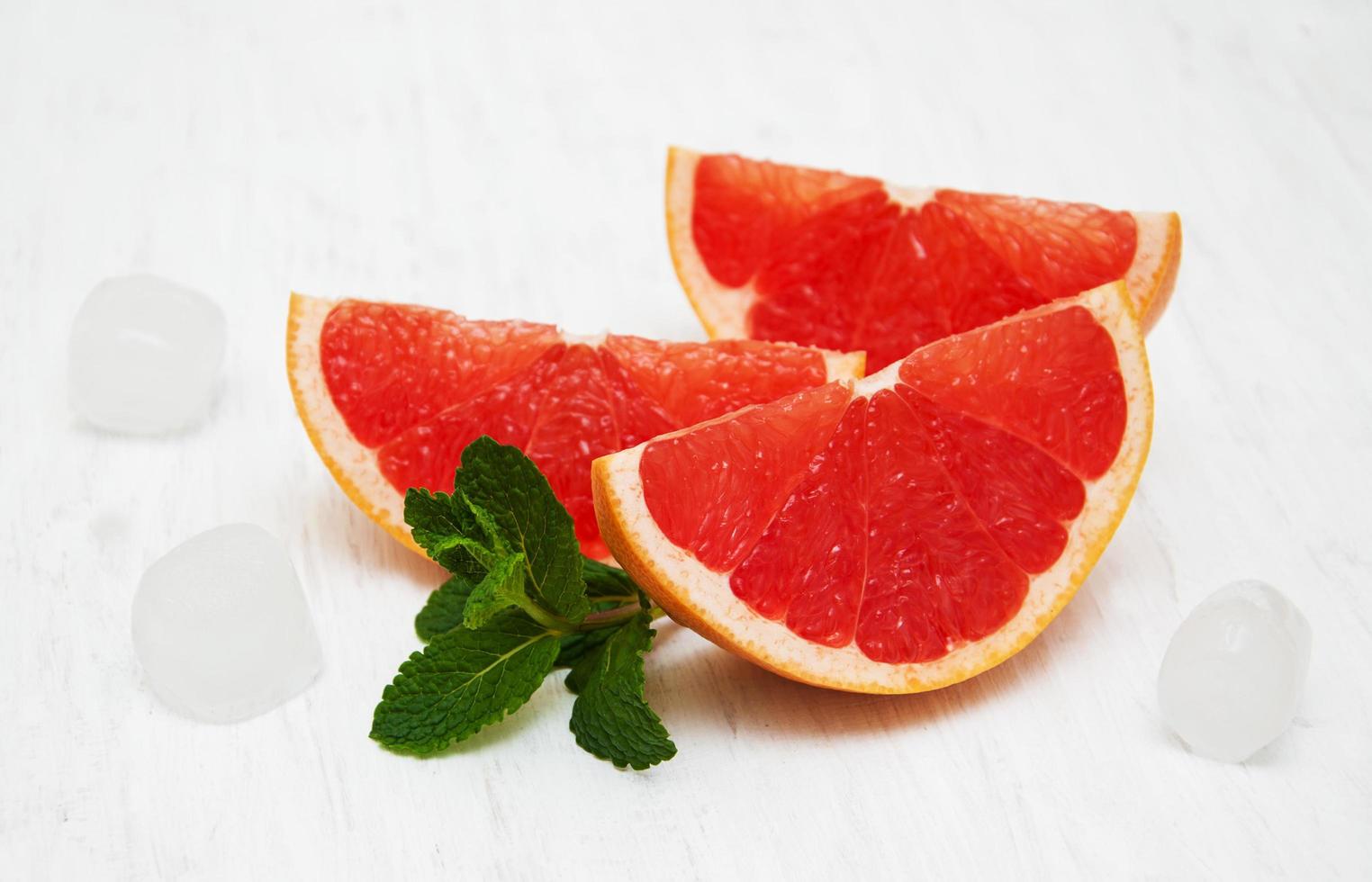 grapefruit met munt en ijs op een oude witte houten achtergrond foto