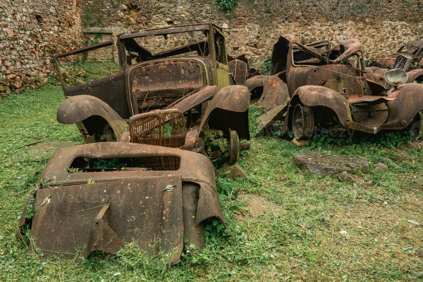 oud roestig auto's links achter in oradour-sur-gllane, Frankrijk. foto