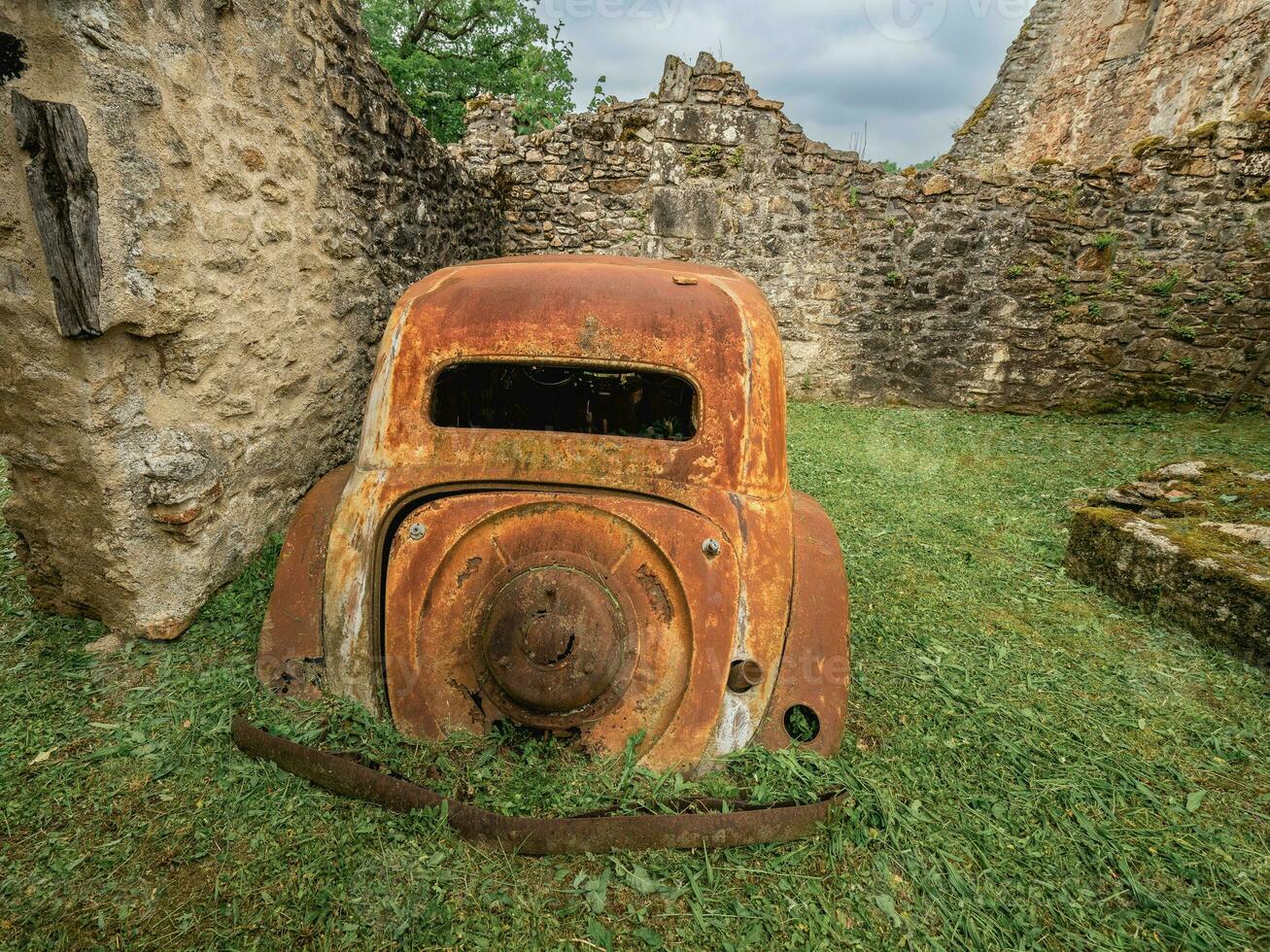 oud roestig auto's links achter in oradour-sur-gllane, Frankrijk. foto