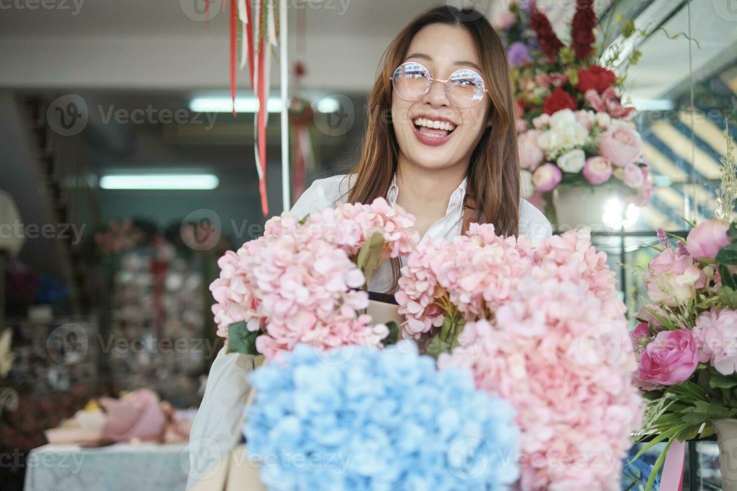 portret van jong mooi Aziatisch vrouw bloemist met bloemen bundel levering, glimlachen en op zoek Bij camera, lief bedrijf ondernemer, bloem winkel gelukkig werk, helder kleurrijk flora boeket op te slaan. foto
