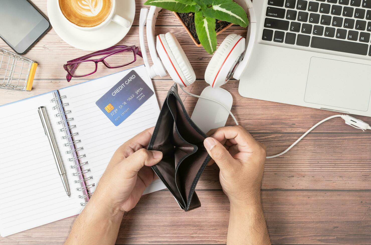 een Mens Open portemonnee zonder geld Aan de bureau bestaande van credit kaarten Aan notitieboekje foto