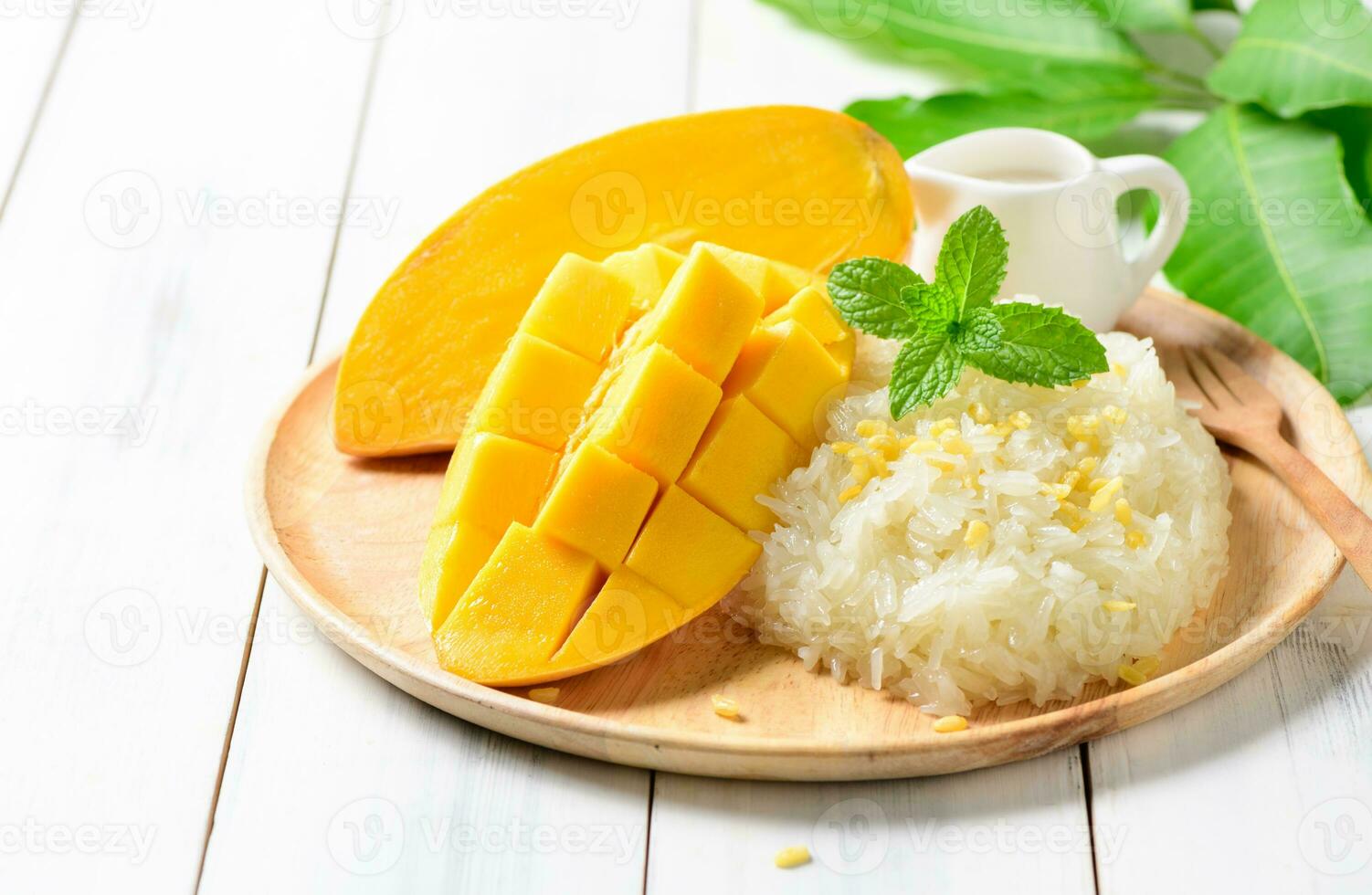 rijp mango en kleverig rijst- met kokosnoot melk Aan wit hout achtergrond, foto