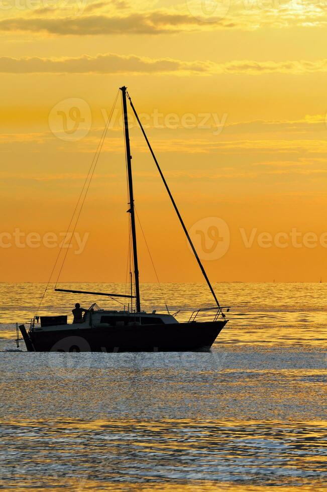 zeilboot bij zonsondergang foto