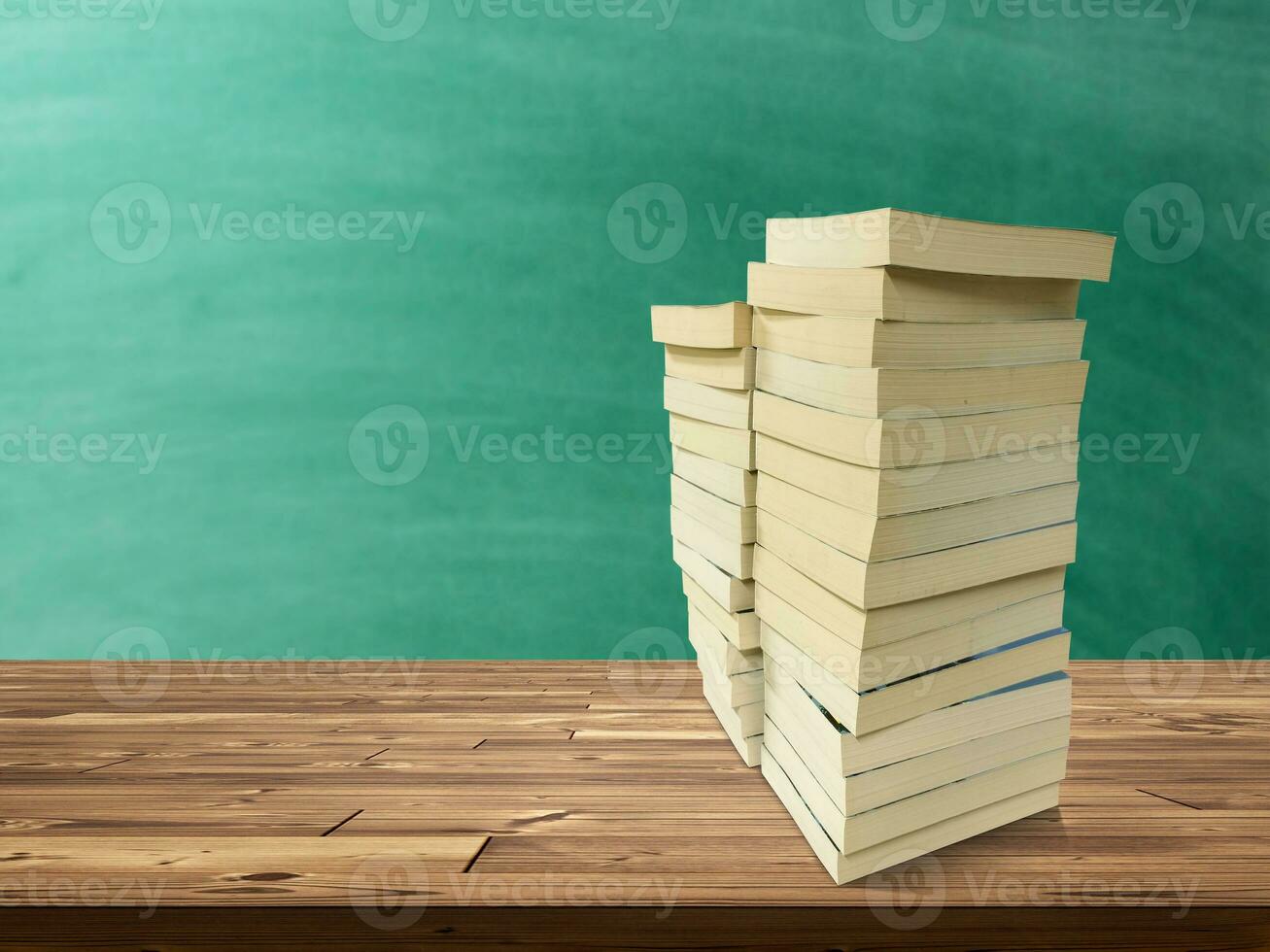 stack van boeken Aan houten tafel Daar is een groen bord achtergrond. foto