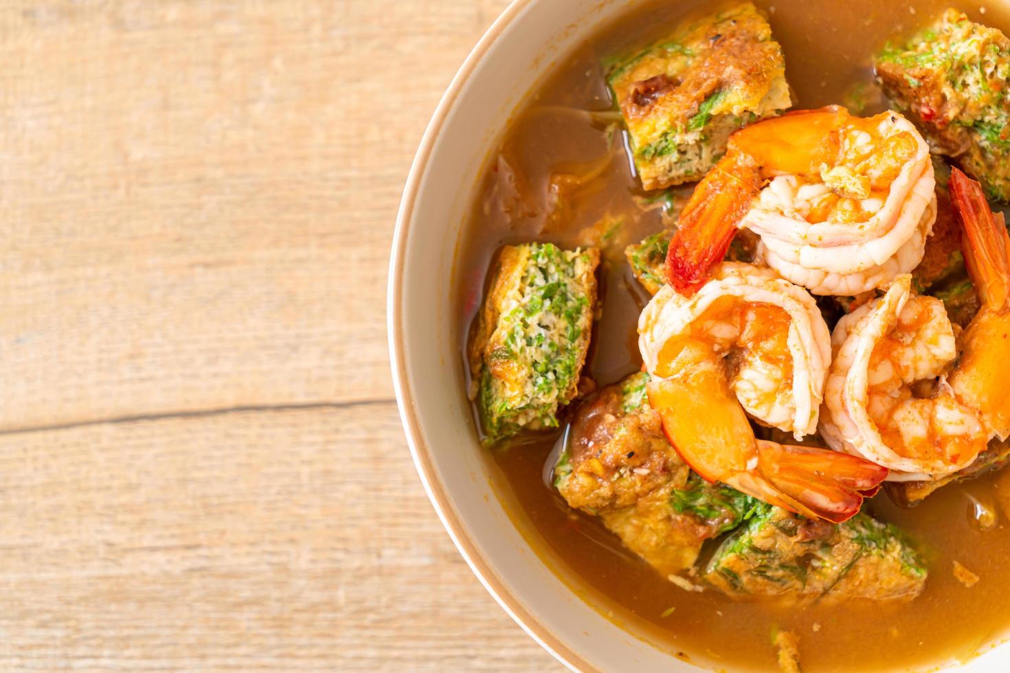 zure soep gemaakt van tamarindepasta met garnalen en groenteomelet - Aziatisch eten foto