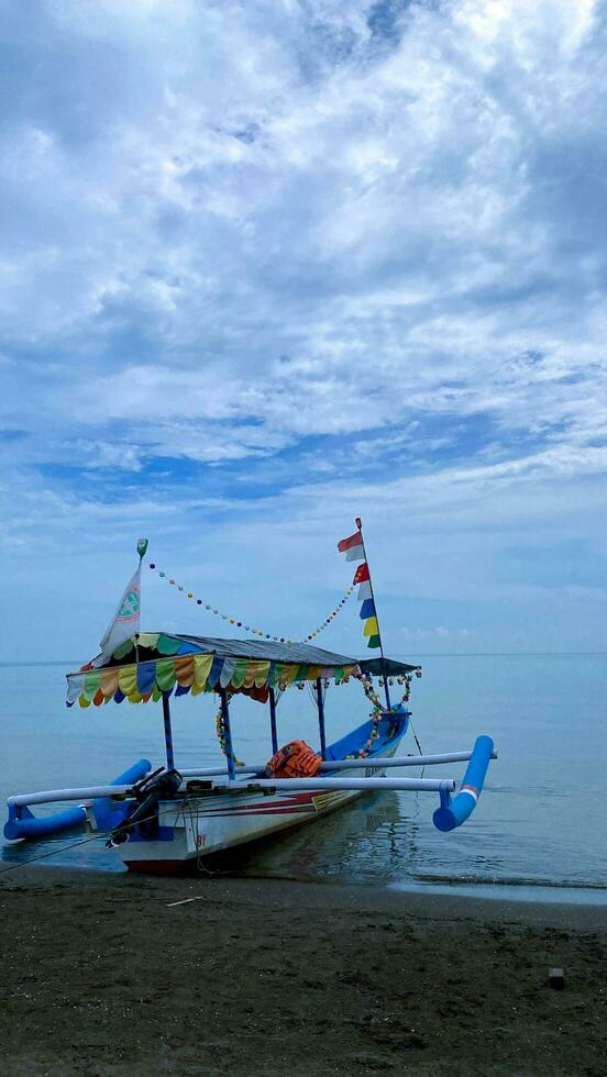 een boot Aan de strand water met blauw lucht en wolken in de achtergrond foto