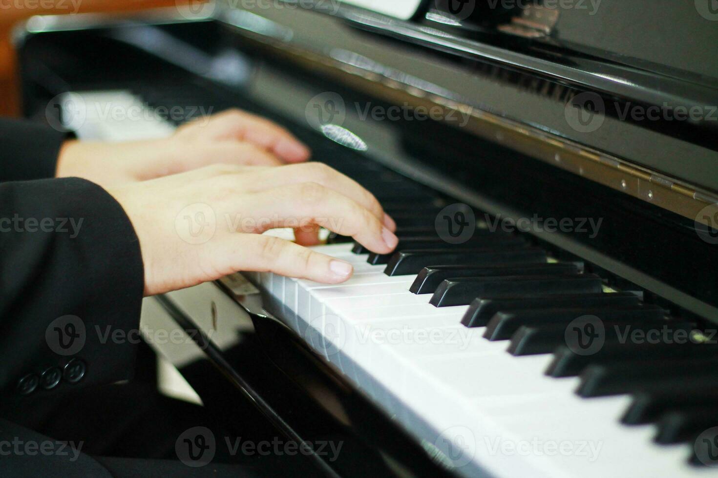 handen van een Mens in een zwart pak en wit overhemd spelen muziek- van de piano. zacht focus foto van de muzikanten van een bruiloft ceremonie Bij de kerk.