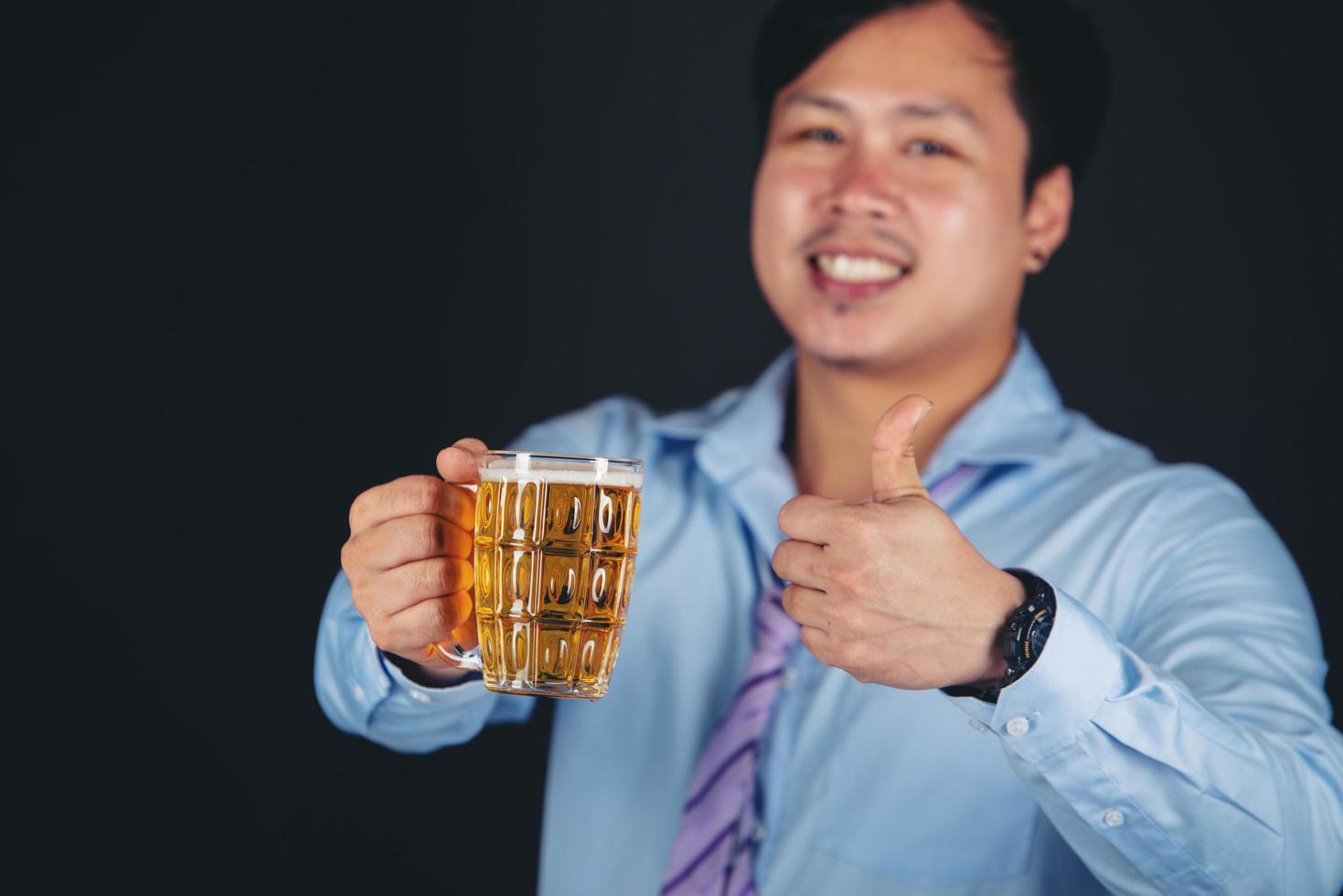 bijgesneden close-up van een man die thuis bier drinkt foto