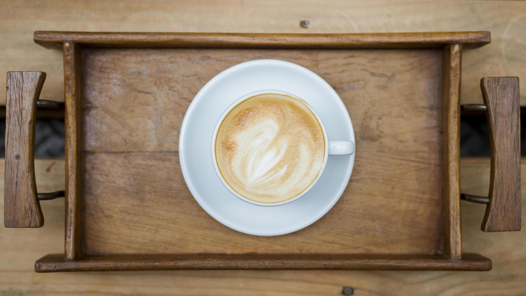 hete latte art op houten tafel achtergrond foto