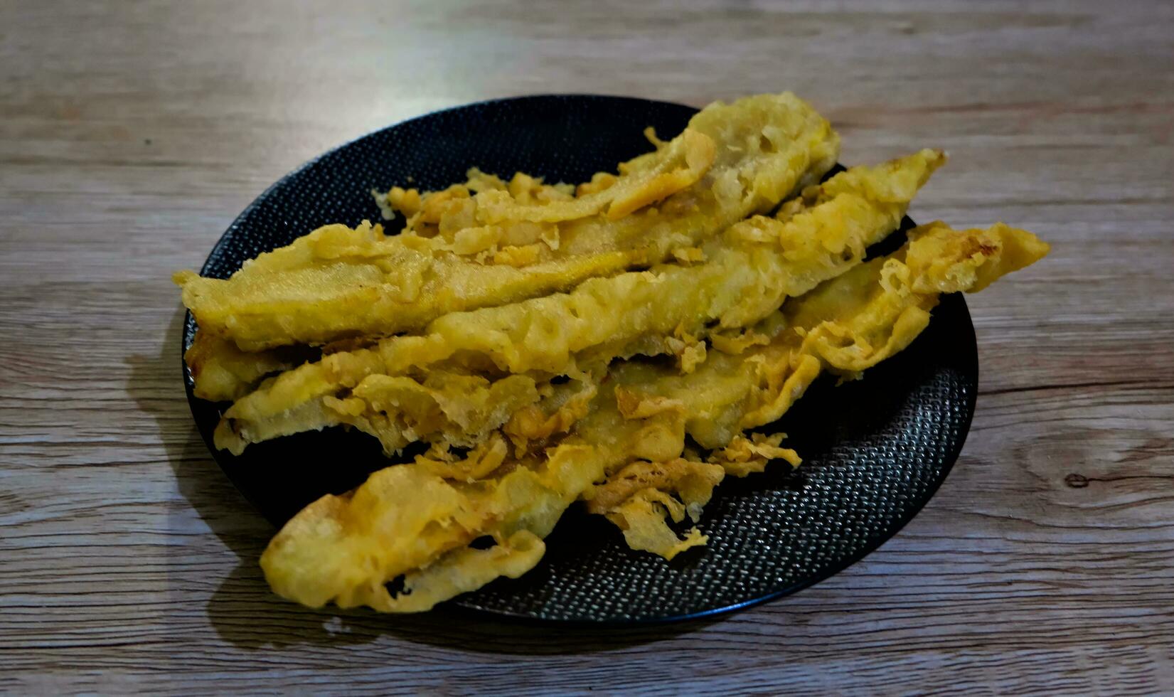 gebakken bananen Aan een zwart bord Aan een houten achtergrond foto