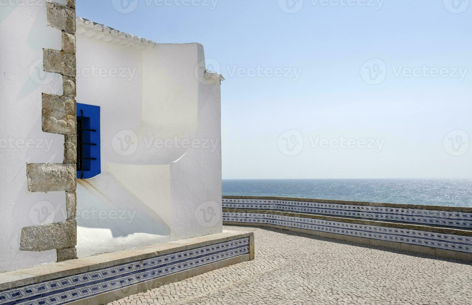 blauw een wit kerk in Ericeira, met de zee in de achtergrond foto