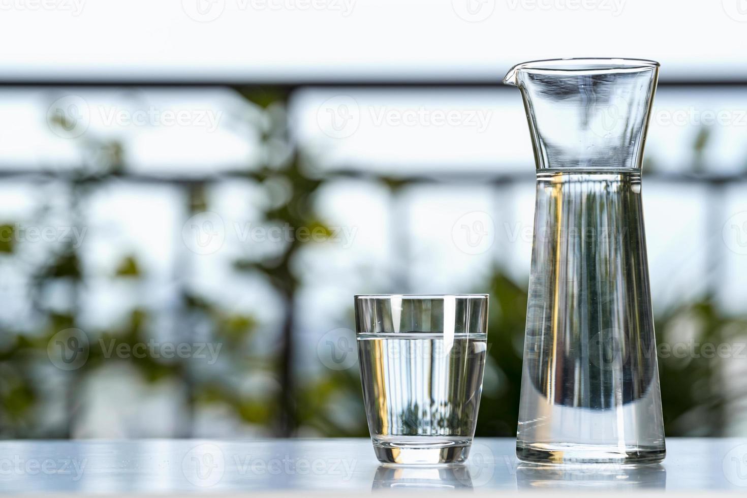 drink water glazen kan met glas op tafel in de tuin thuis foto