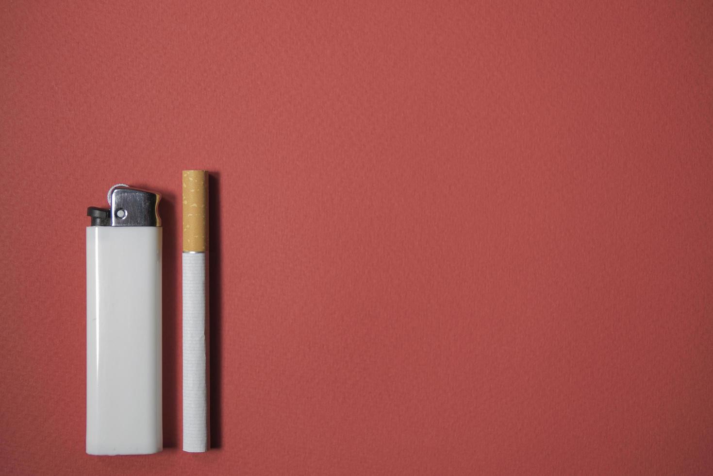 sigaret en aansteker op een rode achtergrond foto