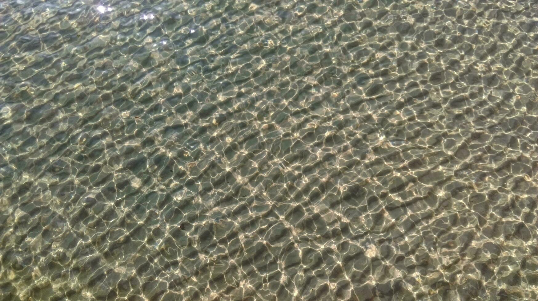 zand drijft onderwater- met zon schittering Aan de water foto