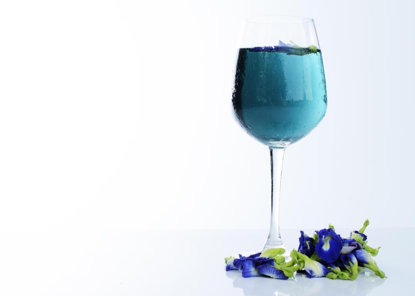 blauwe drank met vlindererwt kruiden op witte achtergrond foto