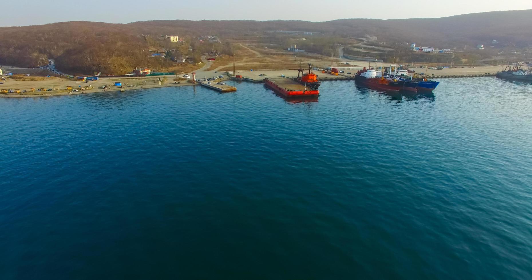 luchtoverzicht van de kustlijn van het Russische eiland met een pier en schepen foto