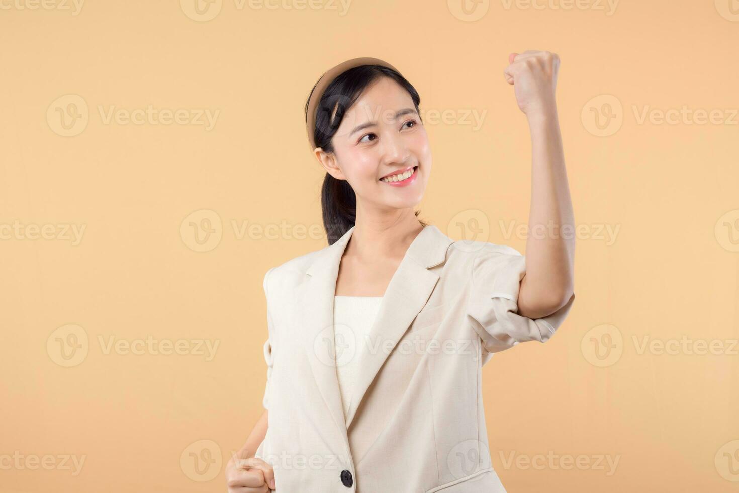 studio portret van gelukkig geslaagd zelfverzekerd jong Aziatisch bedrijf vrouw. mooi jong dame in wit jasje glimlachen Bij camera staand geïsoleerd Aan solide beige kleur copyspace achtergrond foto