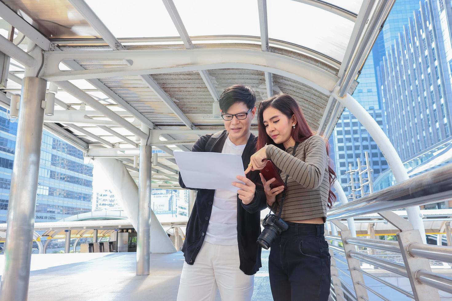 Aziatische toeristen controleren informatie over accommodatie en attracties tijdens het concept van het leven van een gelukkig stel happy foto