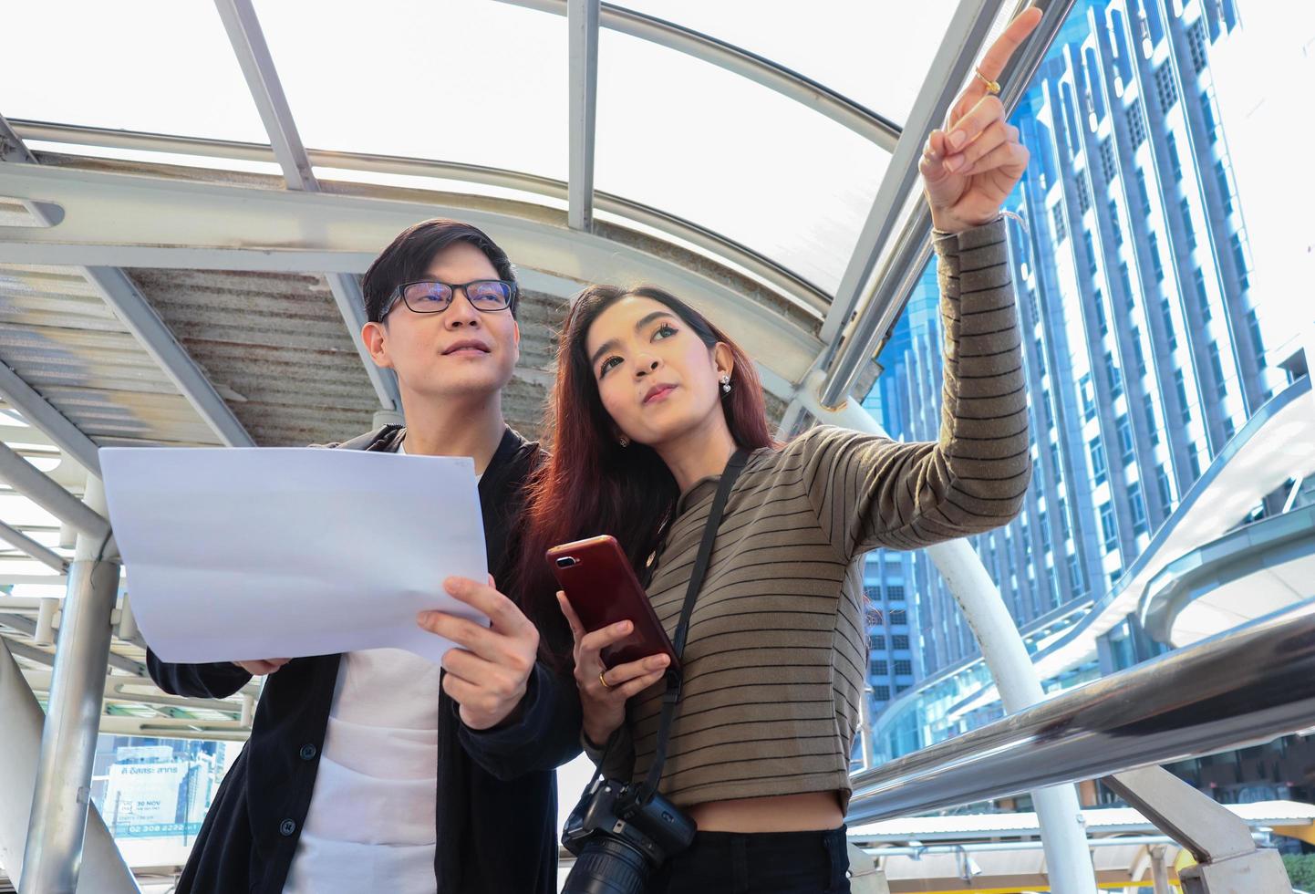 Aziatische toeristen controleren informatie over accommodatie en attracties tijdens het concept van het leven van een gelukkig stel happy foto