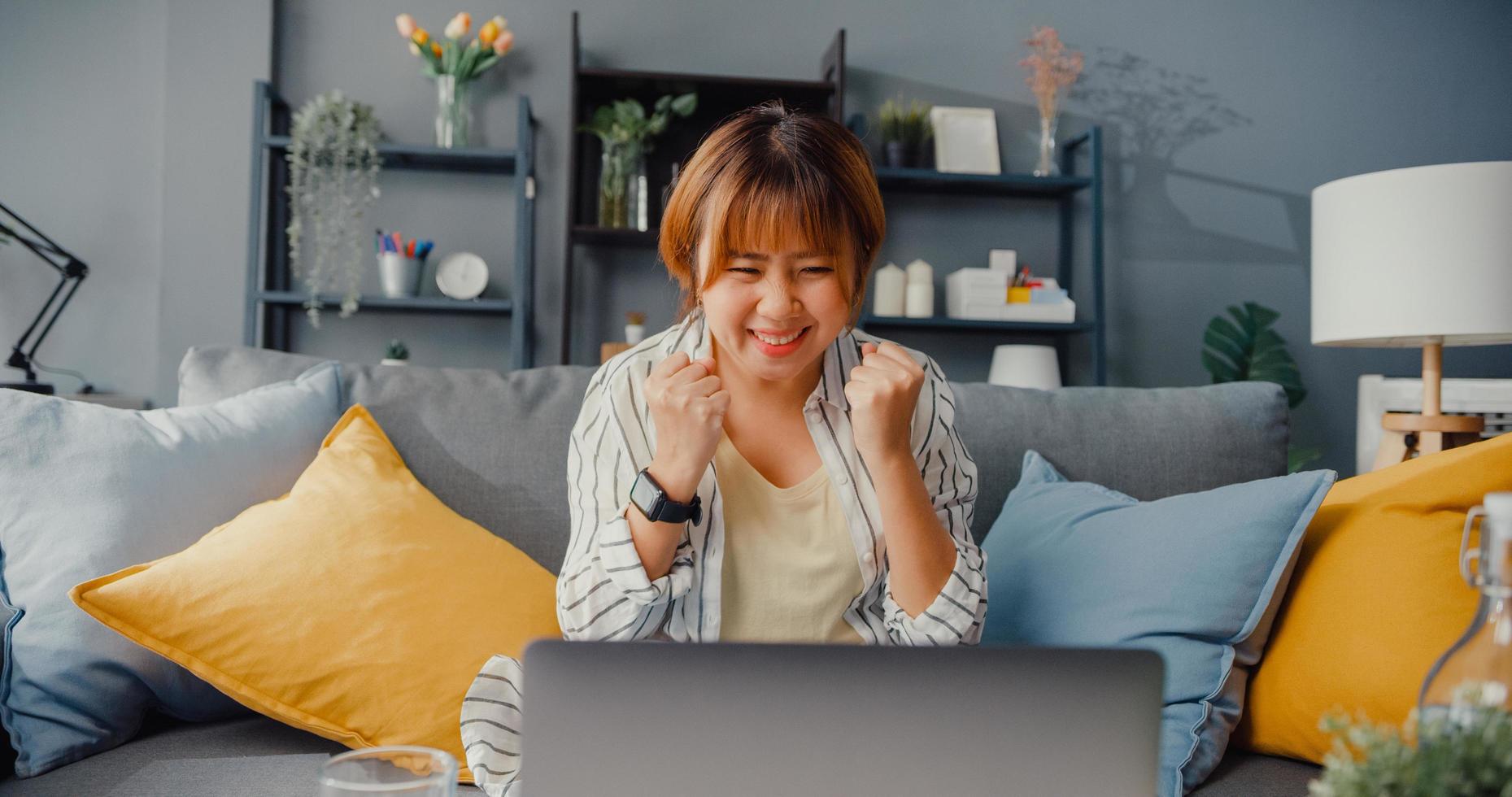 freelance azië dame vrijetijdskleding met behulp van laptop online leren in de woonkamer thuis foto