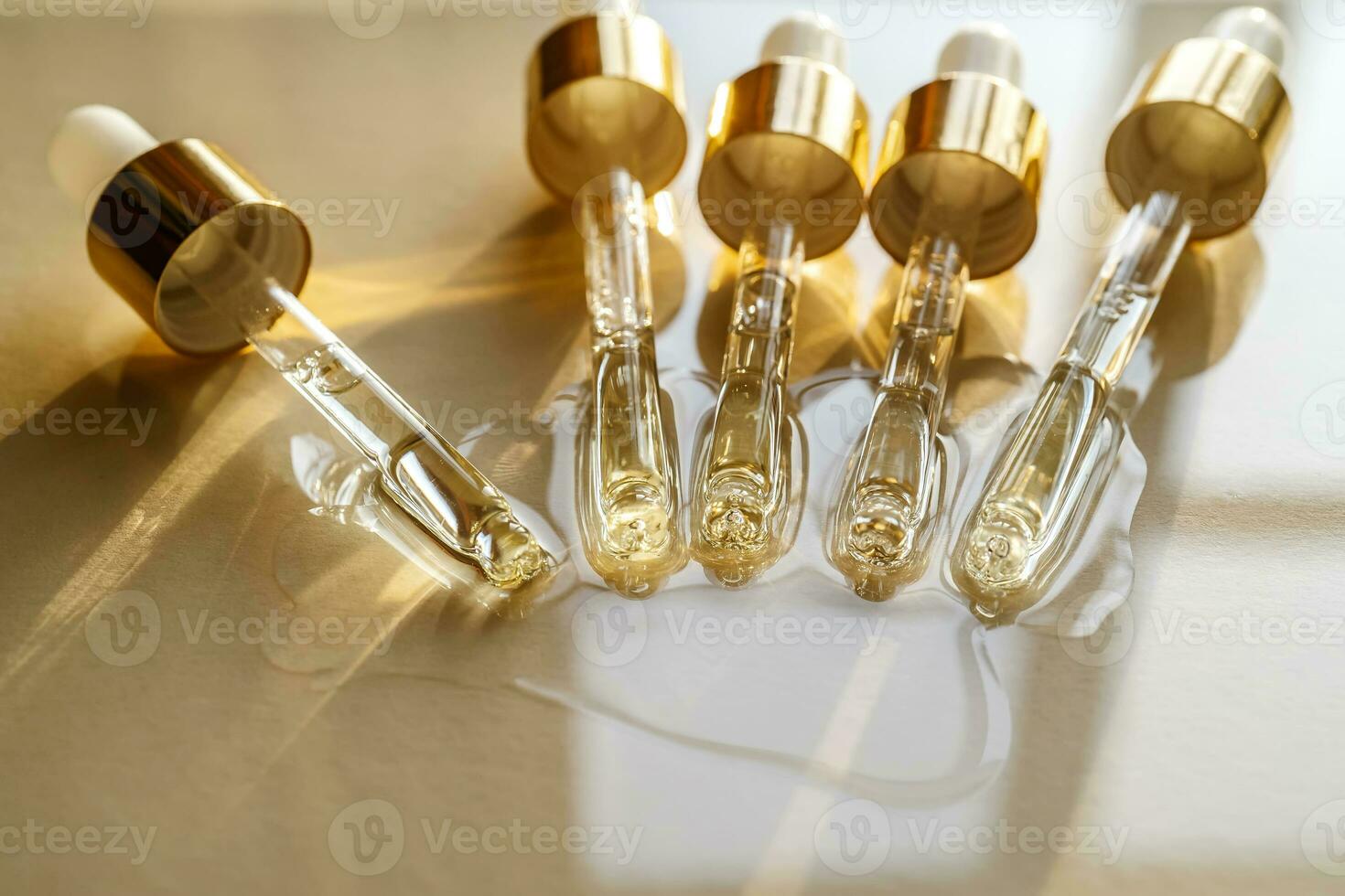 pipetten met olie of serum Aan een gouden achtergrond. foto