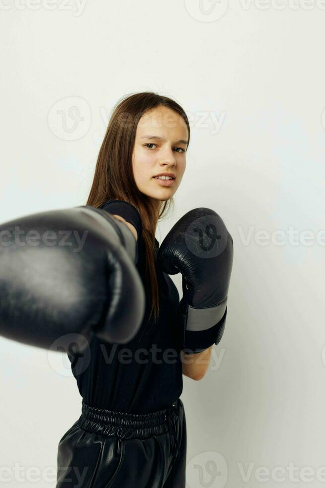 mooi meisje in zwart sport- uniform boksen handschoenen poseren geschiktheid opleiding foto