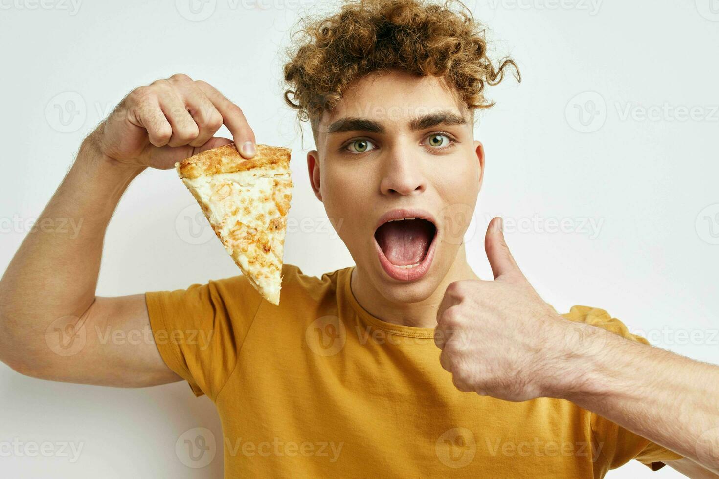 knap vent aan het eten pizza poseren detailopname licht achtergrond foto