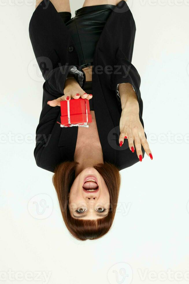 aantrekkelijk vrouw poseren met rood geschenk doos verrassing licht achtergrond foto