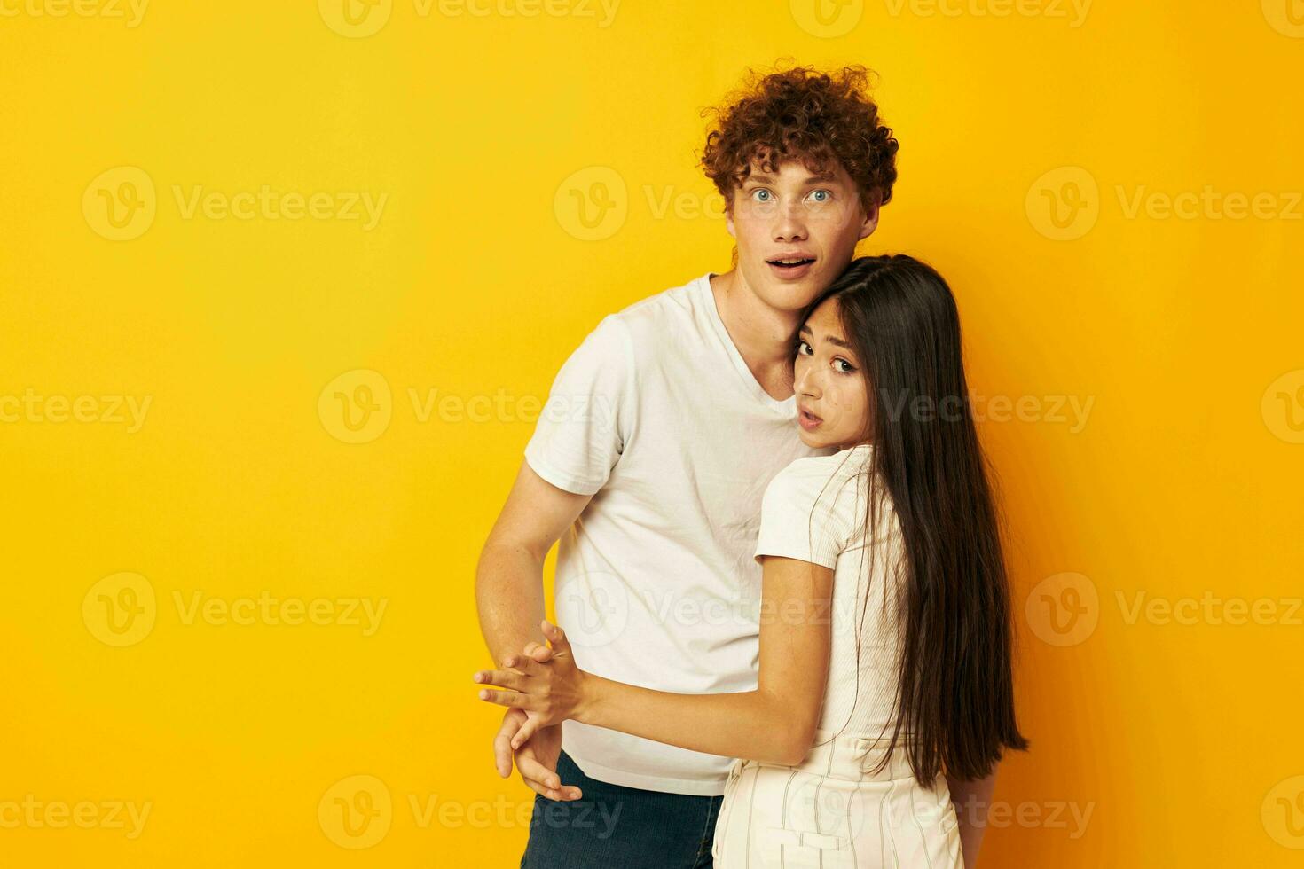 tieners staan knuffelen elk andere in wit t-shirts geel achtergrond ongewijzigd foto