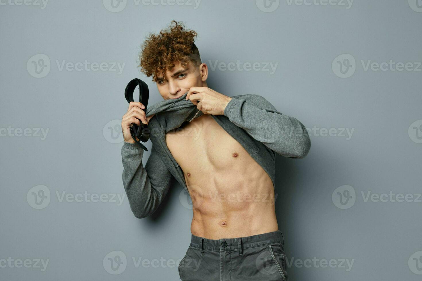 aantrekkelijk Mens poseren opgeblazen torso model- grijs achtergrond foto