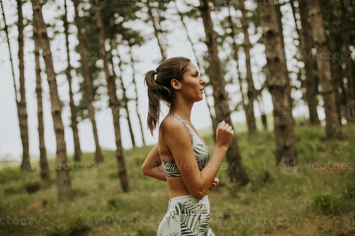 jonge fitness vrouw draait op bospad foto