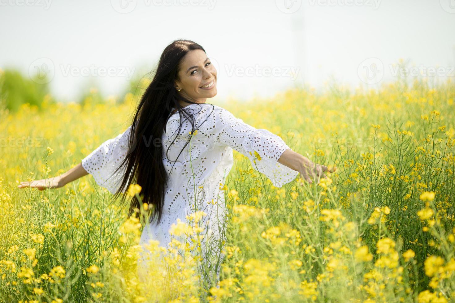 jonge vrouw in het koolzaadveld foto