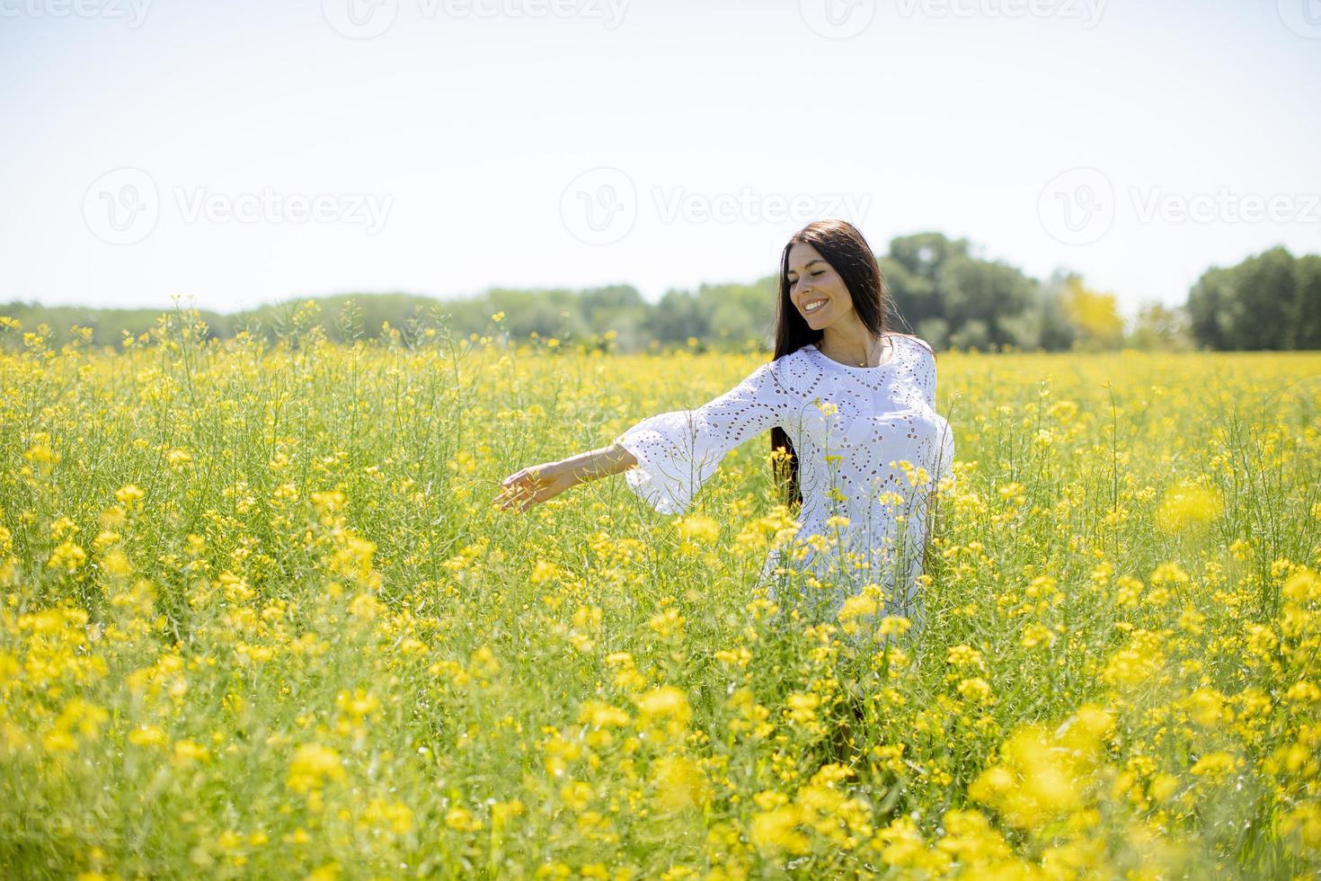 jonge vrouw in het koolzaadveld foto